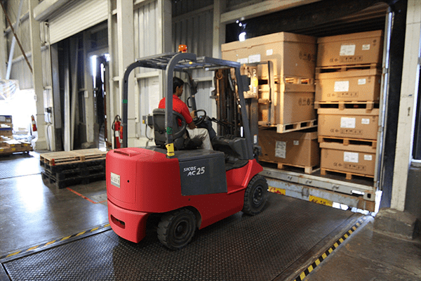 Forklift moving pallets of goods