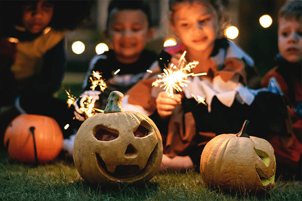 halloween pumpkins and sparklers held by children