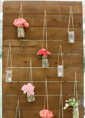 flowers in jars hanging on pallets